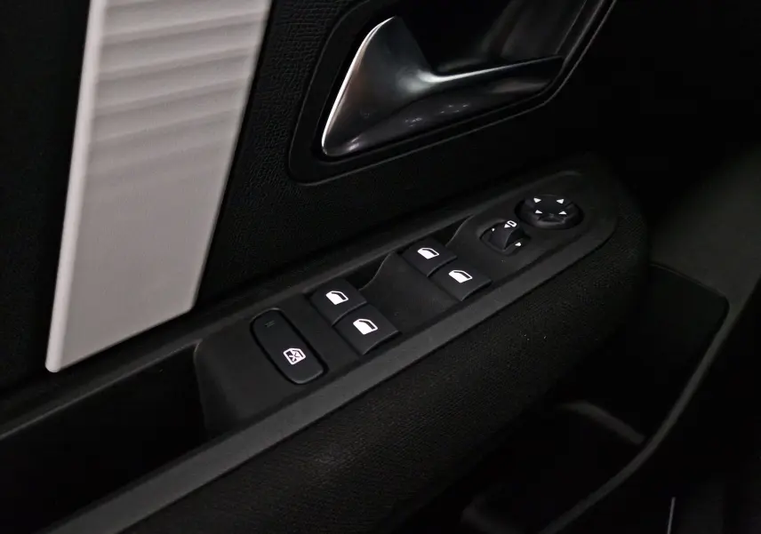 Gros plan sur la commande des vitres et rétroviseurs côté conducteur d'une Citroën C4 2025 gris mercury/noir.