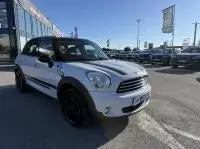 MINI Countryman Cooper 122 Pack Chili blanc vue 3/4 avant droit, jantes noires, stationné en extérieur devant un bâtiment.