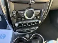 Gros plan sur la console centrale noire d'une MINI Countryman Cooper 122 Pack Chili blanche, avec commandes et boutons.