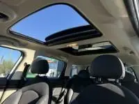 Intérieur d'une MINI Countryman Cooper 122 Pack Chili 2012, vue sur le toit ouvrant panoramique et sièges noirs.