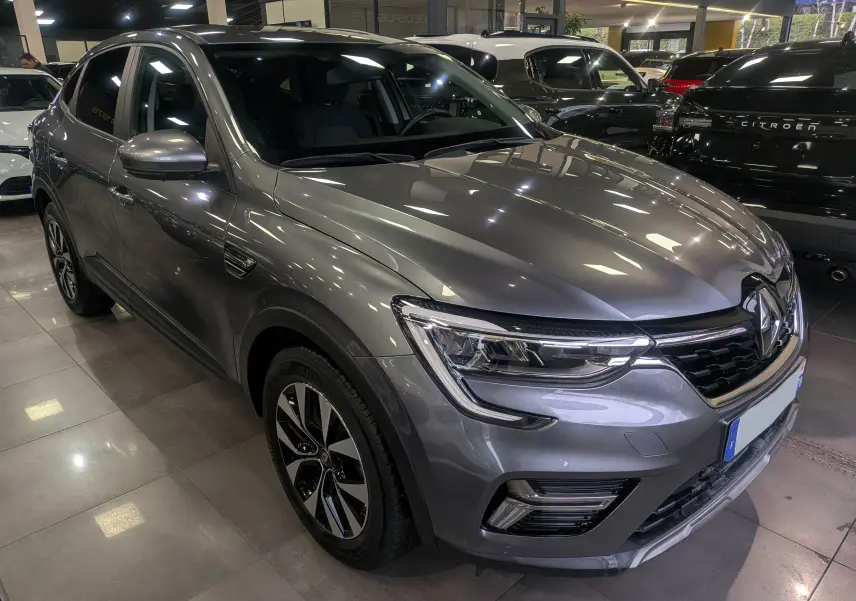 Renault Arkana gris métal en 3/4 avant droit, mettant en valeur ses phares LED et jantes bi-ton 17 pouces.