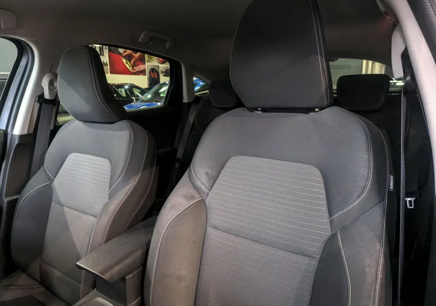 Gros plan sur les sièges avant en tissu gris foncé de la Renault Arkana TCe 140 CH EDC BUSINESS, intérieur spacieux.