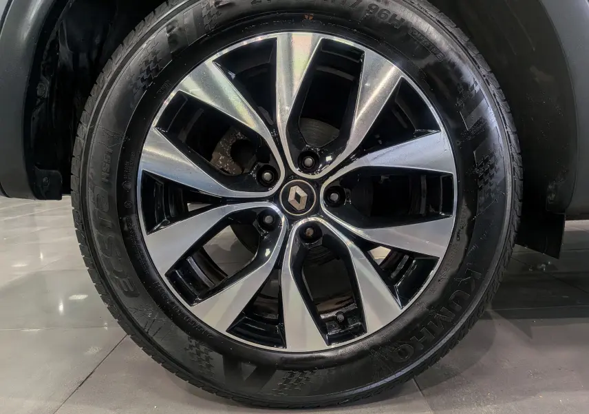 Gros plan sur la roue avant droite du Renault Arkana TCe 140 gris métal avec jante alliage bi-ton 17 pouces.