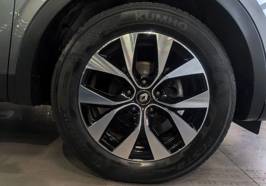 Gros plan sur la roue avant gauche du Renault Arkana TCe 140 Business gris métal avec jante alliage bi-ton 17 pouces.