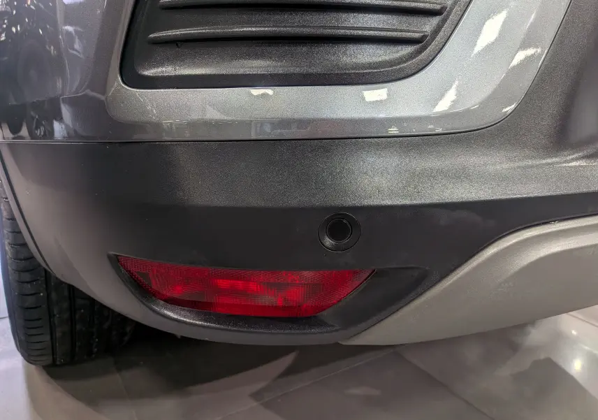 Gros plan sur le feu arrière droit et le pare-chocs gris métal d’un Renault Arkana TCe 140 CH EDC BUSINESS 2022.