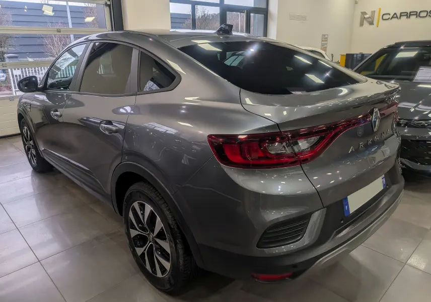 Vue 3/4 arrière droite d'une Renault Arkana gris métal 2022 avec jantes bi-ton et feux arrière étirés.