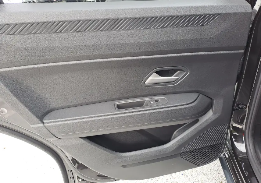 Vue rapprochée de la porte arrière droite noire nacrée du Dacia Bigster 2025, avec poignée et commande de fenêtre.