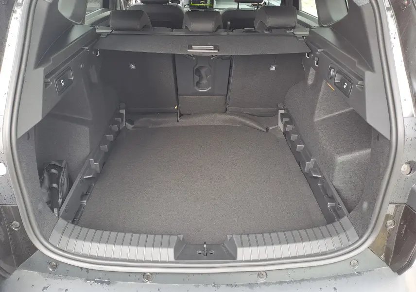 Coffre ouvert vu de l'arrière du Dacia Bigster noir nacré, montrant un espace de chargement spacieux et bien fini.