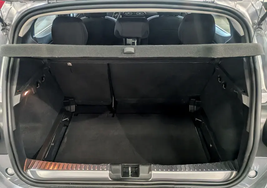 Vue arrière ouverte du coffre spacieux d'une Dacia Sandero TCe 90 CH Journey 2025 gris schiste avec banquette arrière noire.