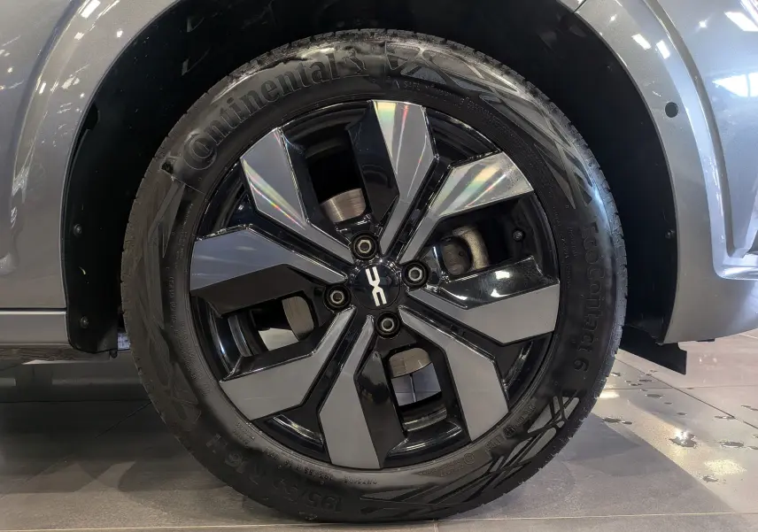 Gros plan sur la roue avant droite d'une Dacia Sandero gris schiste, avec jante alliage bicolore et pneu Continental.