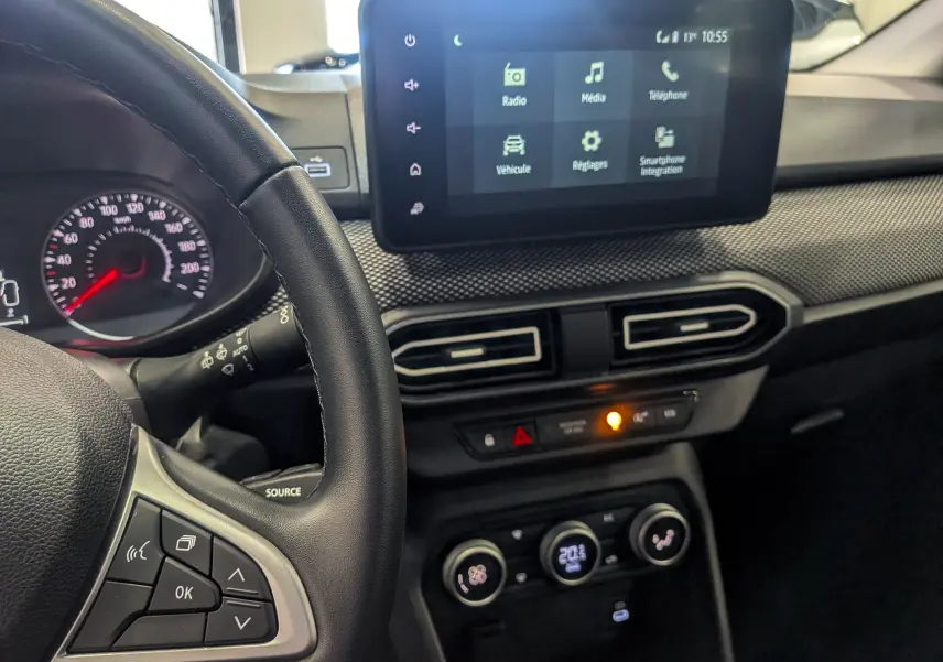 Vue intérieure du tableau de bord de la Dacia Sandero TCe 90 2025, avec écran tactile et volant à gauche en cuir noir.