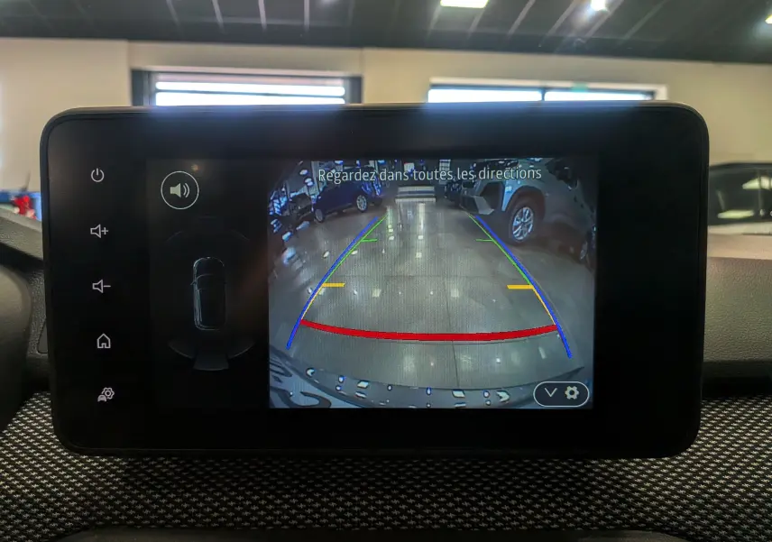 Écran central montrant la caméra de recul avec lignes de guidage dans un Dacia Sandero gris schiste, vue intérieure.