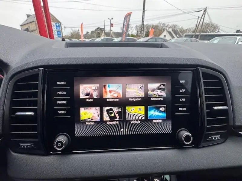 Vue intérieure centrée sur l’écran tactile multifonction du tableau de bord du Skoda Karoq gris Diamant 2025.
