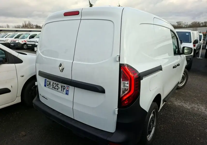 Vue 3/4 arrière droite d’un Renault Kangoo blanc utilitaire avec portes arrière battantes et feux arrière rouges.