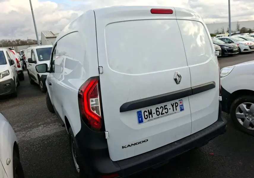 Vue 3/4 arrière droite d’un Renault Kangoo blanc 2023 avec feux arrière allumés et plaque d’immatriculation française.
