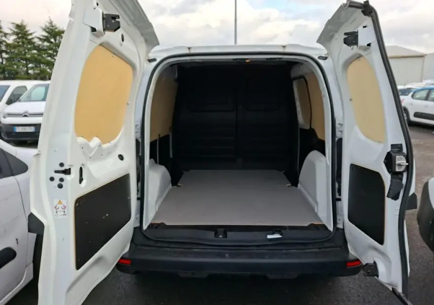 Vue arrière du Renault Kangoo blanc 2023 avec portes ouvertes montrant l’espace de chargement vide et doublure intérieure beige.