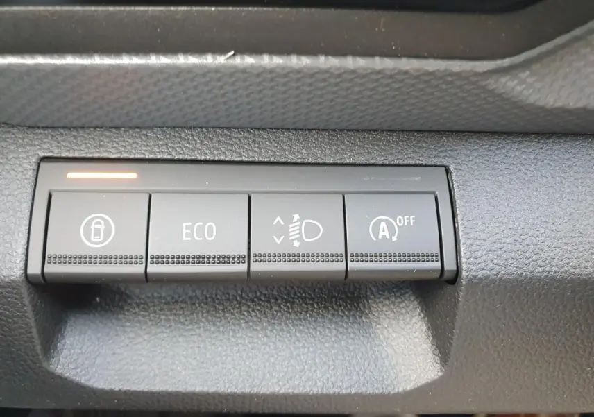 Gros plan sur les boutons de commande du tableau de bord du Dacia Duster 2026, finition gris schiste.