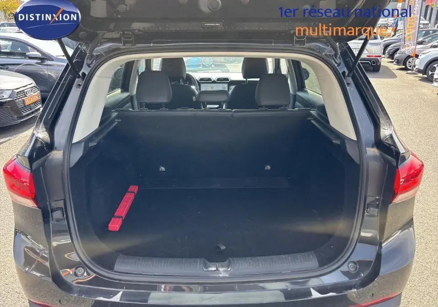 Coffre ouvert vu de l'arrière d'un MG Motor ZS 1.5L Hybrid+ 197ch Luxury en Pebble Black Metal, intérieur noir.