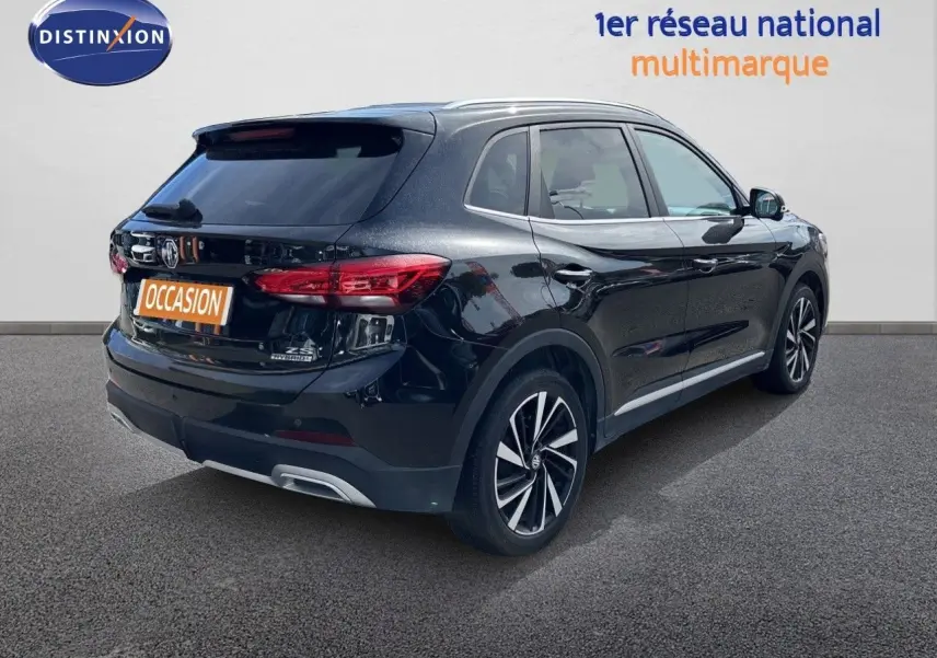Vue 3/4 arrière droite du MG ZS 1.5L Hybrid+ 197ch Luxury en noir Pebble Black Metal avec jantes alliage bicolores.
