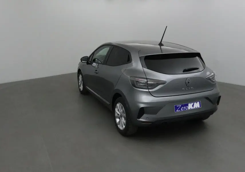 Renault Clio V gris schiste vue 3/4 arrière droit, avec protections latérales chromées et vitres teintées.