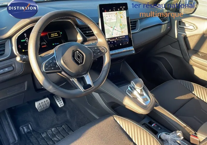Vue intérieure avant du Renault Captur E-Tech hybride 2025, avec volant cuir, écran tactile vertical et sellerie noire.