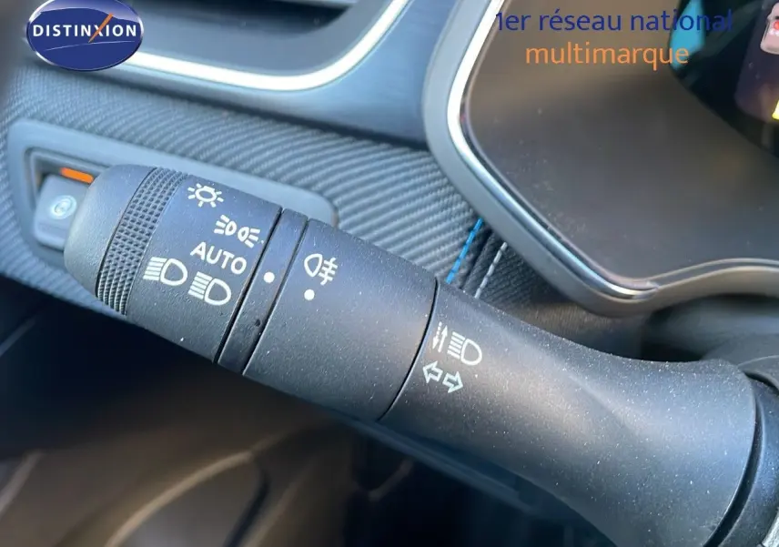 Gros plan sur la commande des phares et clignotants du Renault Captur E-Tech hybride 2025, intérieur noir.