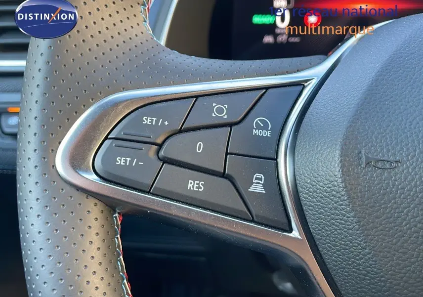 Gros plan sur les commandes au volant en cuir perforé du Renault Captur E-Tech hybride 2025, finition Esprit Alpine.