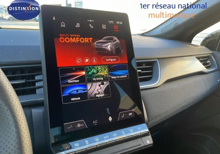 Vue intérieure du tableau de bord du Renault Captur E-Tech Hybrid 2025 avec écran tactile central vertical et finition tissu gris.