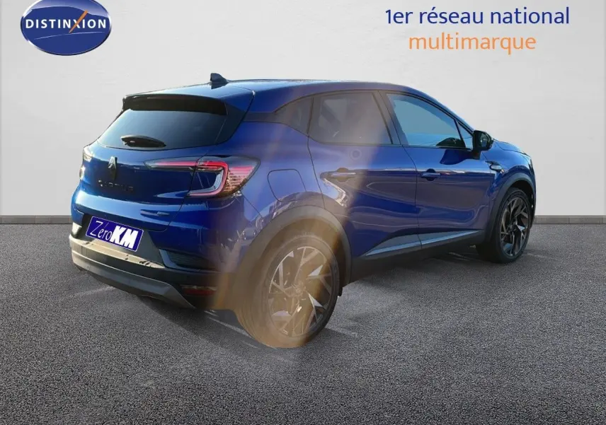 Vue 3/4 arrière droite du Renault Captur E-Tech hybride bleu Iron Metal avec jantes noires et toit noir contrasté.