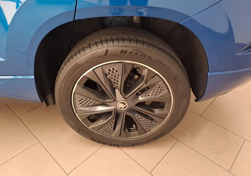 Gros plan sur la roue arrière droite du SKODA KAROQ Bleu RS 2025 avec jante noire au design moderne.