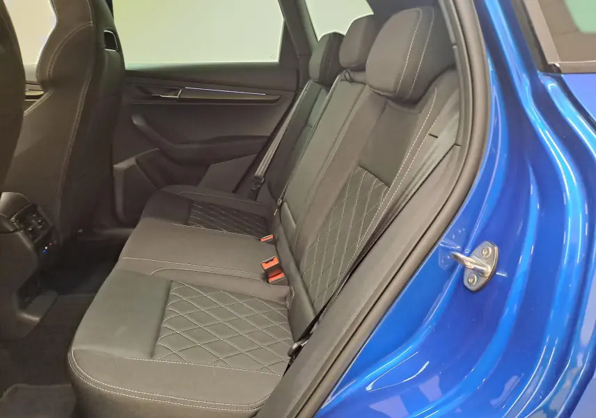 Vue intérieure côté droit des sièges arrière en tissu gris avec surpiqûres sur un SKODA KAROQ Bleu RS 2025.