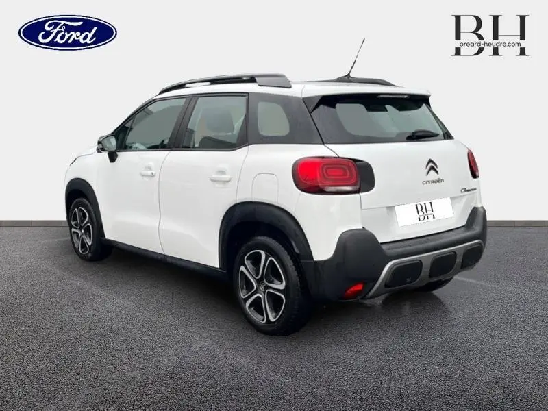Citroën C3 Aircross blanc Natural White vue 3/4 arrière droit avec barres de toit et jantes distinctives.