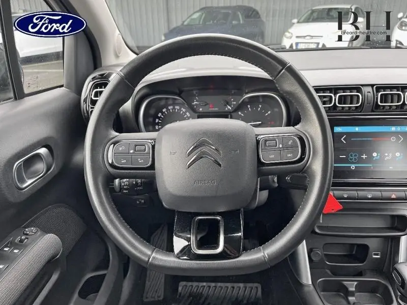 Vue intérieure centrée sur le volant cuir noir du Citroën C3 Aircross 2019 avec tableau de bord et écran tactile.