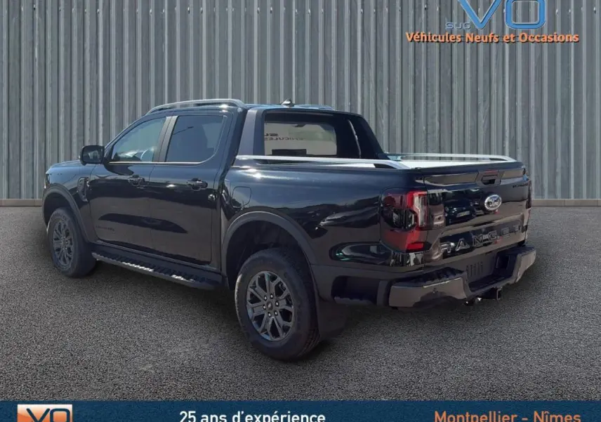 Vue 3/4 arrière droite du Ford Ranger noir 2025 avec barres de toit, marchepieds et jantes alliage 18 pouces.