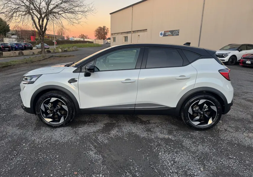 Vue de profil côté gauche du Renault Captur E-Tech blanc nacré avec toit noir et jantes noires au design moderne.