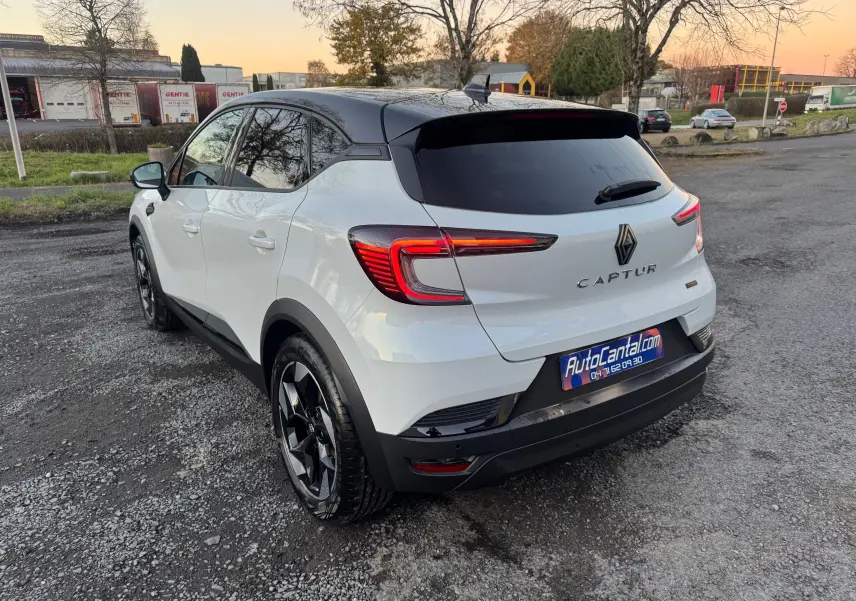 Vue 3/4 arrière droite d’un Renault Captur blanc nacré avec toit noir, feux arrière LED et jantes noires.