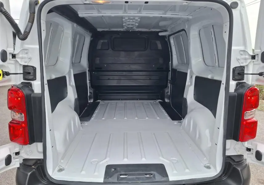 Vue arrière du fourgon Opel Vivaro blanc 2025, montrant l'espace de chargement vide et les portes ouvertes.