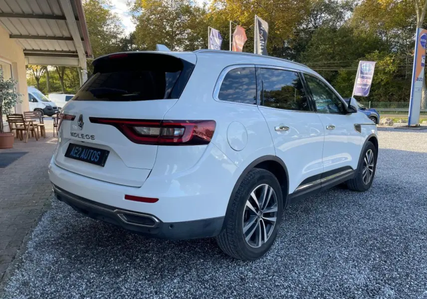Renault Koleos blanc vu en 3/4 arrière droit, avec vitres teintées et jantes alliage distinctives.