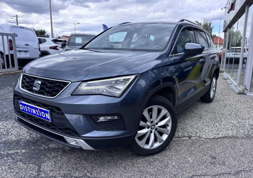SEAT Ateca gris foncé en 3/4 avant droit, avec calandre noire et jantes alliage 17 pouces visibles.