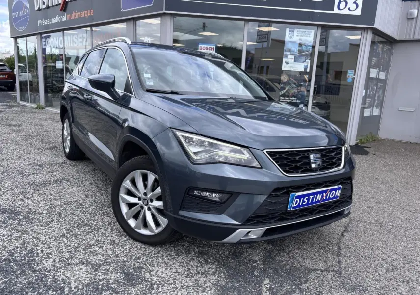 SEAT Ateca gris foncé en vue 3/4 avant droit, avec calandre chromée et jantes alliage 17 pouces visibles.