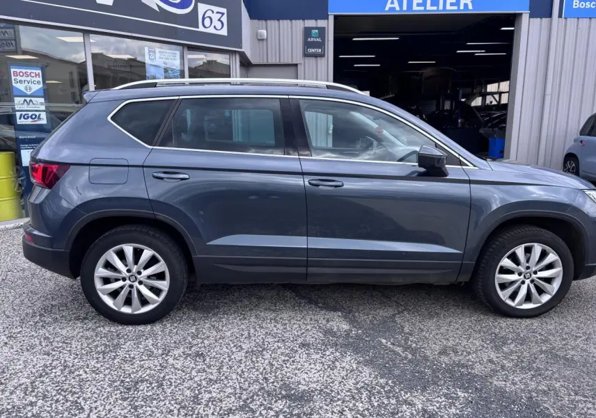 Vue de profil côté gauche d'un SEAT Ateca gris foncé garé devant un atelier Bosch Service.