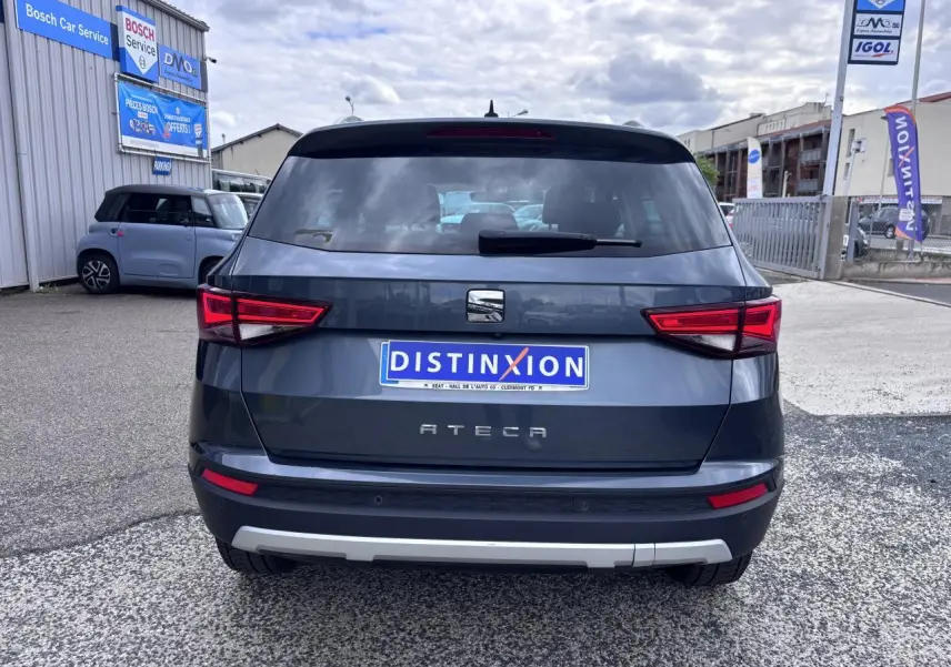 Vue arrière d'un SEAT Ateca gris foncé avec feux LED et plaque d'immatriculation Distinxion visible en extérieur.