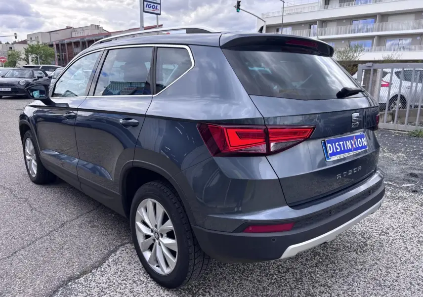 Vue 3/4 arrière droite d'un SEAT Ateca gris foncé avec jantes alliage et feux arrière LED, stationné en extérieur.