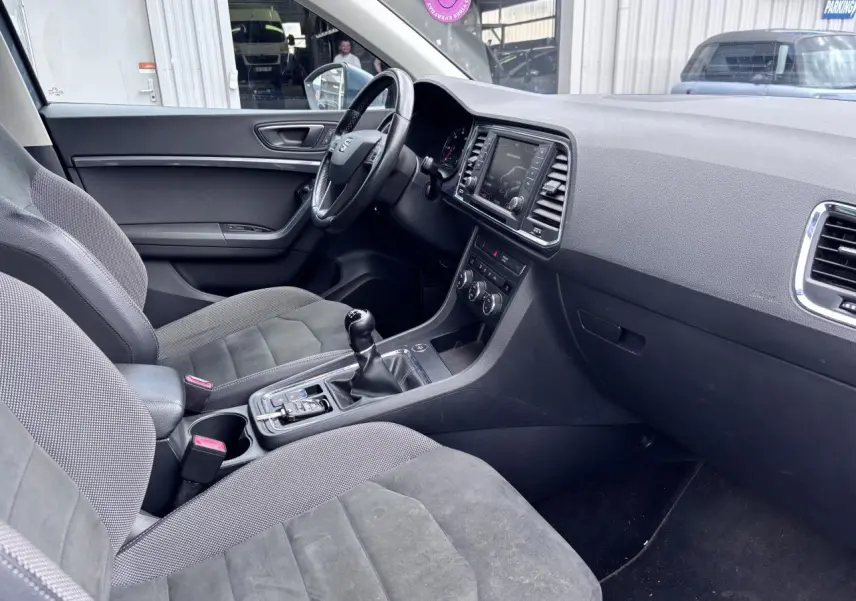 Intérieur avant droit du SEAT Ateca gris foncé, montrant tableau de bord, volant cuir et console centrale avec boîte manuelle.