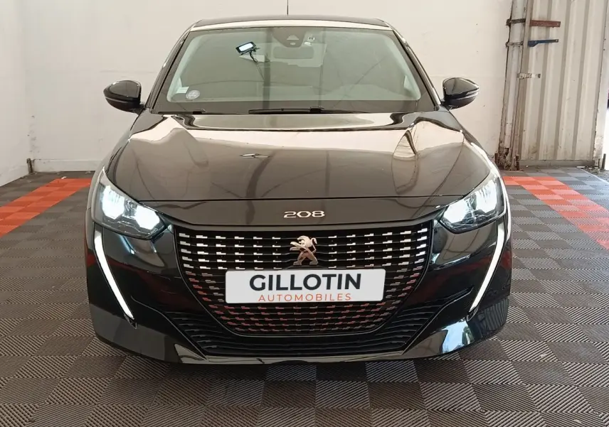 Vue frontale d'une Peugeot 208 PureTech 100 S&S Style noire avec phares LED allumés et calandre distinctive.