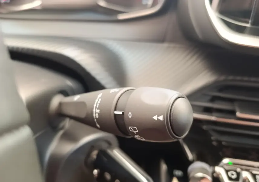 Gros plan sur la commande d’essuie-glace noire dans l’habitacle d’une Peugeot 208 PureTech 100 S&S Style 2022.