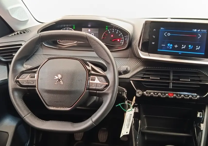 Vue intérieure centrée sur le volant cuir multifonctions et l’écran tactile du tableau de bord de la Peugeot 208 noire.