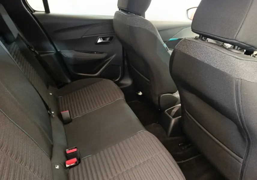Vue intérieure arrière de la Peugeot 208 PureTech 100 noire, montrant la banquette et les dossiers des sièges avant.