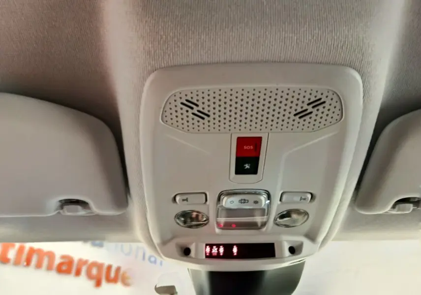 Vue intérieure en gros plan du plafonnier avec commandes et bouton SOS d'une Peugeot 208 noire de 2022.