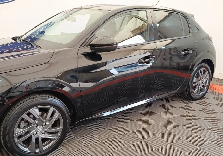 Vue latérale droite d'une Peugeot 208 PureTech 100 S&S Style noire avec jantes alliage et poignées chromées.